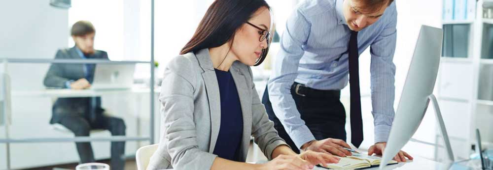 Employees looking through automative processes on work desk